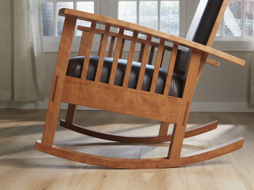 Handmade figured cherry rocking chair with mortis and tenon joinery, traditional hand tied spring foundation and italian leather upholstery.