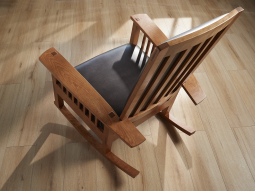 Seat view of handmade figured cherry rocking chair with mortis and tenon joinery, traditional hand tied spring foundation and italian leather upholstery.