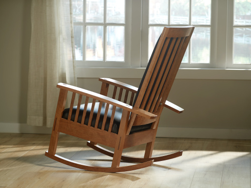 Seat view of handmade figured cherry rocking chair with mortis and tenon joinery, traditional hand tied spring foundation and italian leather upholstery.