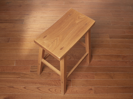 A top angled view of a handmade red oak wooden kitchen bar stool with through mortise wedged tenons visible on the seat top and splayed squared legs.