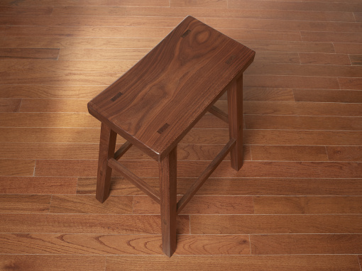 Top angled view of a walnut kitchen bar stool showing the through mortise wedged tenons on the seat top and the splayed legs.