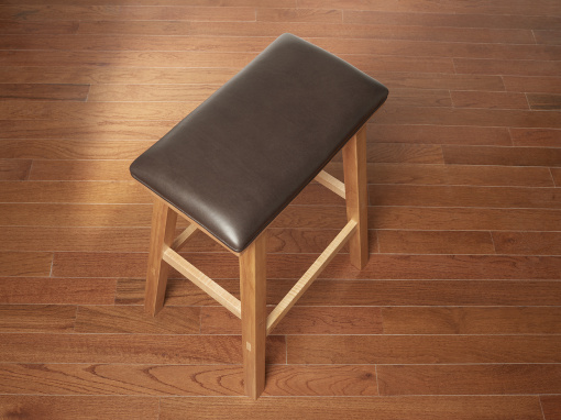 Handmade maple kitchen barstool with brown Italian leather seat on hardwood floor.