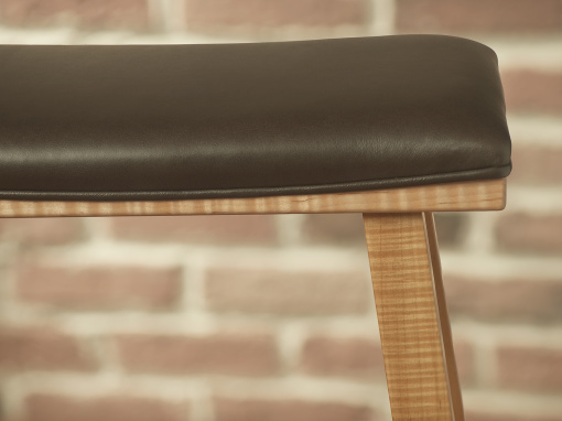 Close-up of Italian leather seat and figured maple frame on handmade barstool.