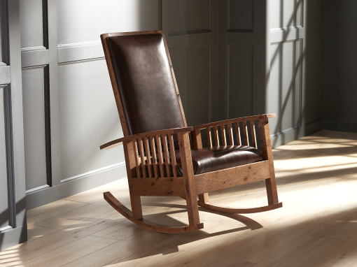 Handmade Arts & Crafts-style rocking chair with leather seat and back, crafted from bark-included oak.
