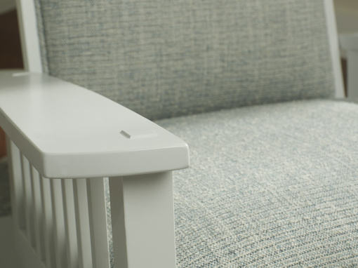 Close-up of white wooden armrest with exposed joinery detail.