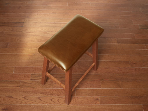 Handmade cherry kitchen barstool with London Apple Italian leather seat on hardwood floor.