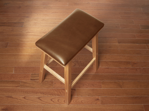 Handmade maple kitchen barstool with brown Italian leather seat on hardwood floor.