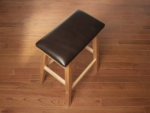 Handmade maple kitchen barstool with brown Italian leather seat on hardwood floor.