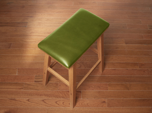 Handmade red oak kitchen barstool with London Apple Italian leather seat on hardwood floor.