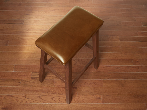 Handmade walnut kitchen barstool with London Bombay Italian leather seat on hardwood floor.