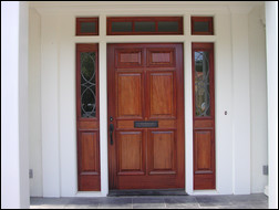 Mahogany exterior 6-panel door with complementary 3-piece transom above and 2 sidelights with custom art glass.