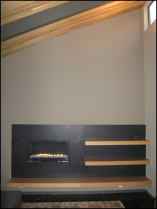 This contemporary fireplace incorporates a stone veneer with wood benches and shelves. Photo courtesy of Johnson Stone (www.johnsonstone.com).