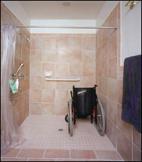This roll-in shower has a flush transition between the floor pan and the adjacent bathroom. Because it is difficult to contain splash without a raised dam, a proactive waterproof membrane was installed under the entire tile floor inside and outside the stall.